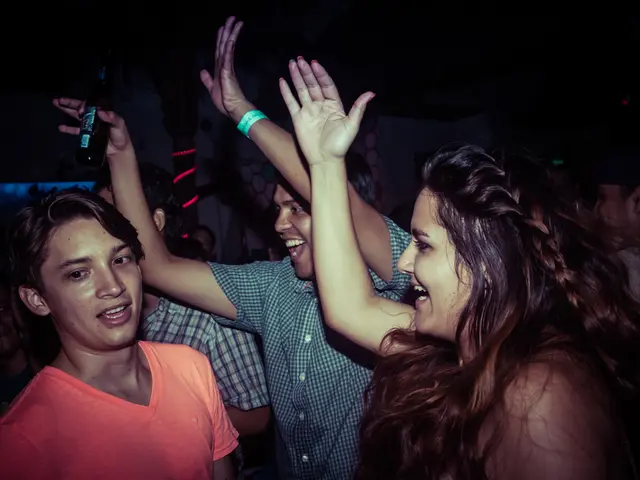 People in here are dancing and a person is holding wine bottle in his hands.