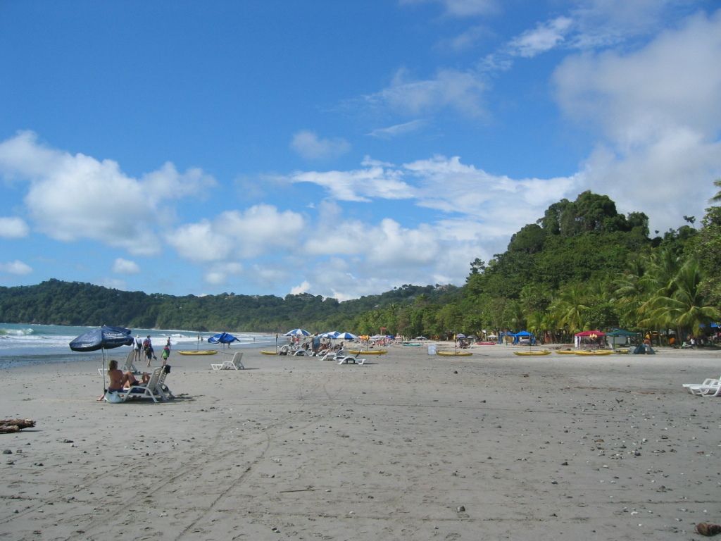 Confident individual in a sleeveless denim jumpsuit featuring wide legs and a drawstring waist,...